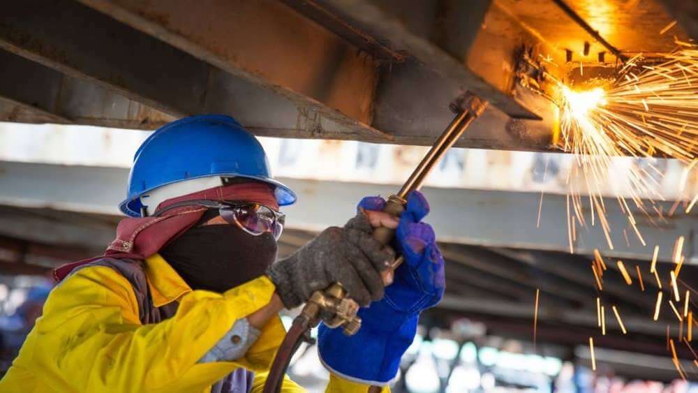 کارگر در حال کار با هوا برش به صورت دستی در حال برش فلز